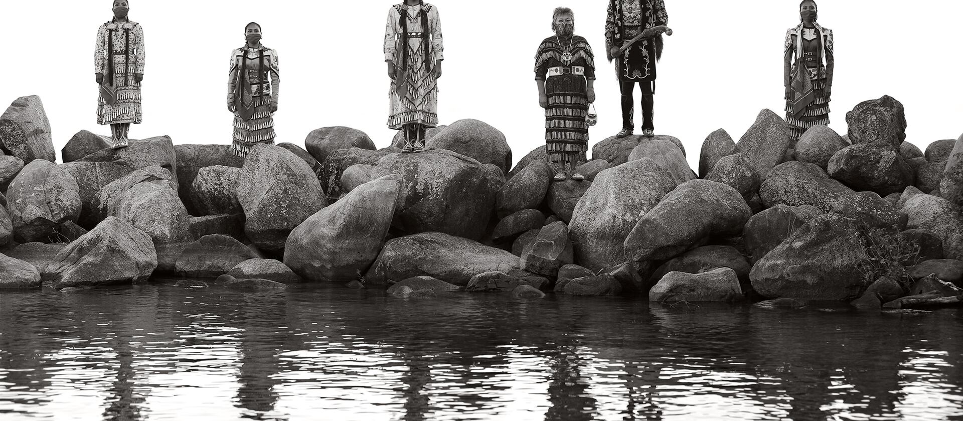 Native dancers stand on rocks at the Old Agency Village in Leech Lake Reservation in Minnesota.
