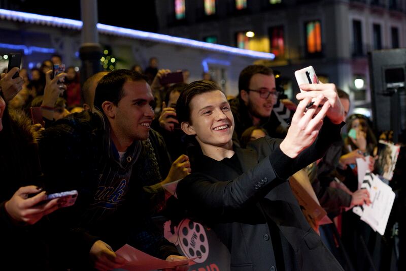 British actor Tom Holland takes a selfie with spectators during the premiere of the film: “In the Heart of the Sea,” in Madrid, Spain.