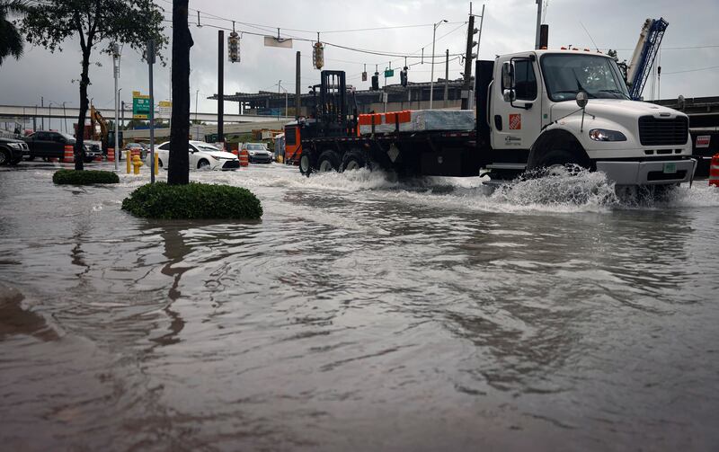 Exit 2 off of the MacArthur Causeway floods over the road and onto the sidewalk during a rainstorm in Miami.