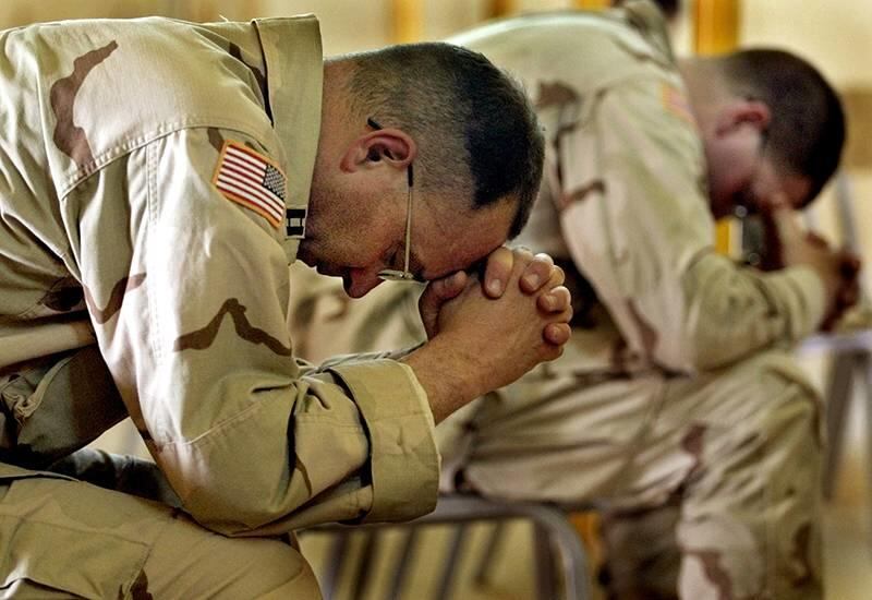 United States Army Chaplain Tim Meader, left, and Chaplain William Lovell, both from Fort Carson, Colorado, bow their heads in prayer during an Easter service at Camp New Jersey, in Kuwait on April 20, 2003.