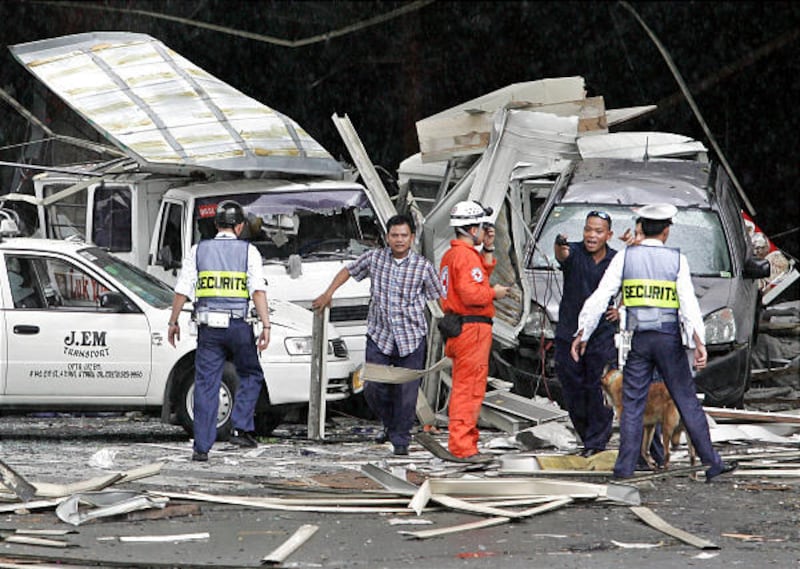 Police and other security examine the damage of the busy Glorietta Shopping Mall at the financial district of Makati city, east of Manila, Philippines moments after a powerful explosion Friday that killed at least six people and wounding 70 others.