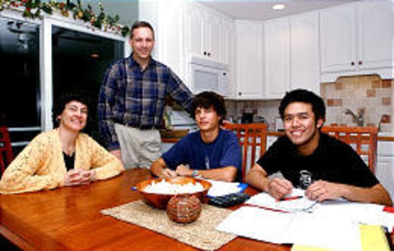 Christina and Howard Pillot, left, help their son Carl and Charttraharn Chareonwong with their homework in their State College, Pa., home. Charttraharn is a foreign exchange student from Thailand.