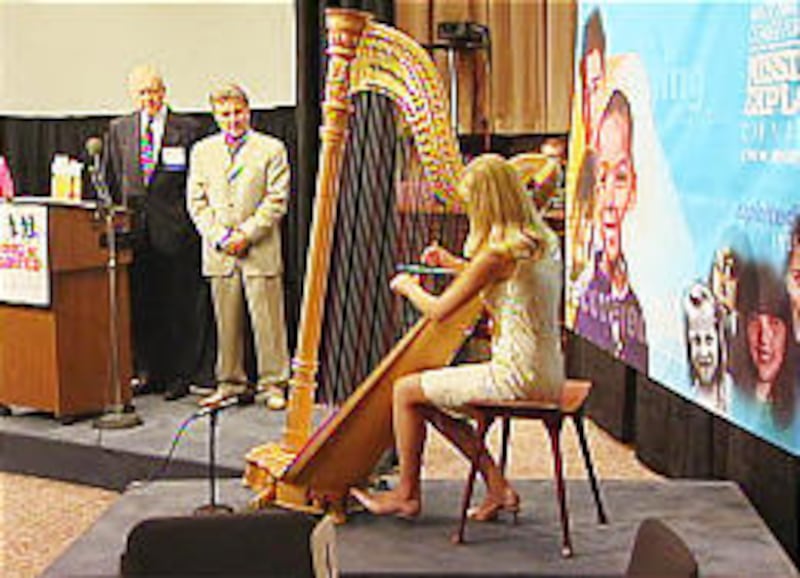Elizabeth Smart plays the harp at an event where she received the National Courage Award from the National Center for Missing and Exploited Children.