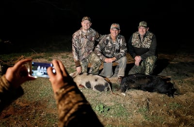 Ty Detmer (center) poses with hunters Anthony Johnson (left) and his father AJ Johnson, from Saratoga Springs, Utah, after hunting wild pigs on Detmer's T14 Ranch Thursday, Nov. 15, 2018, near Freer, Texas.