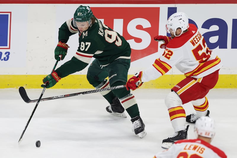 Minnesota Wild left wing Kirill Kaprizov handles the puck against Calgary Flames defenseman MacKenzie Weegar.