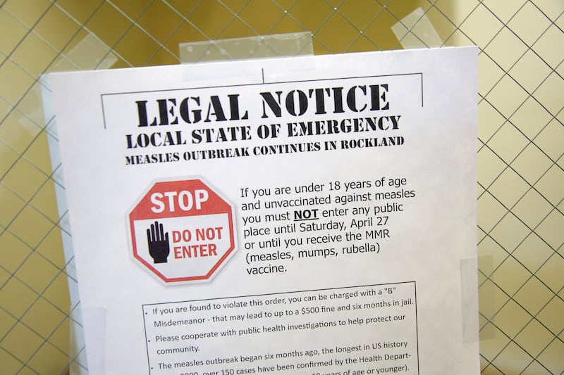 FILE - This Wednesday, March 27, 2019 file photo shows a sign explaining the local state of emergency because of a measles outbreak at the Rockland County Health Department in Pomona, N.Y. Measles is spread through the air when an infected person coughs o