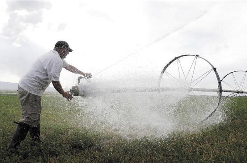 Math teacher Kevin Forsgren adjusts a sprinkler system on his farm in Richmond, Cache County.