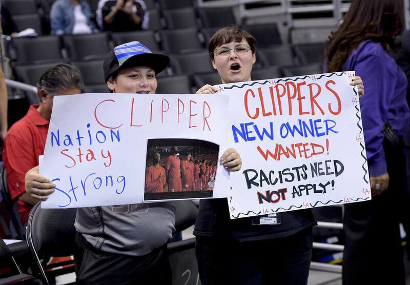 Fans hold up signs in support of the Los Angeles Clippers before Game 5 of an opening-round NBA basketball playoff series between the Clippers and the Golden State Warriors on Tuesday, April 29, 2014, in Los Angeles. NBA Commissioner Adam Silver announced