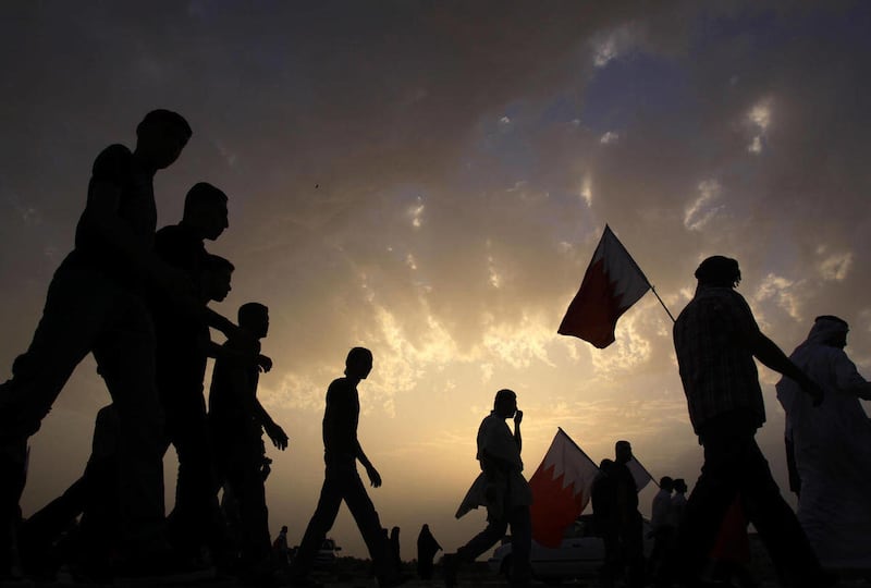 Bahraini anti-government protesters disperse carrying their flags Saturday, March 12, 2011, after a peaceful demonstration by tens of thousands outside the walls of King Hamad bin Isa Al Khalifa's Safriya palace in Sadad, Bahrain, southwest of the capital