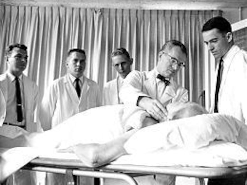 Dr. Maxwell Wintrobe works on a patient as students observe in the late 1940s.