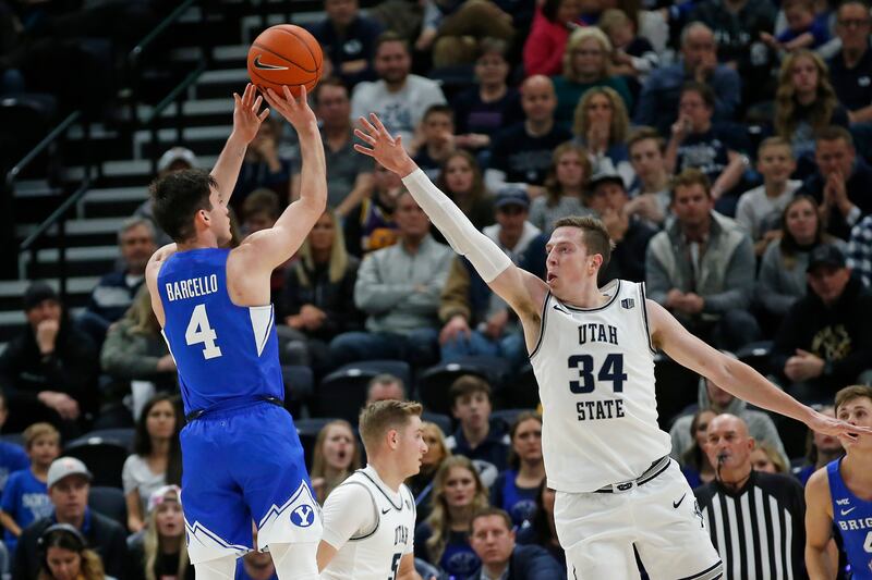 BYU guard Alex Barcello (4) shoots as Utah State forward Justin Bean (34) defends.