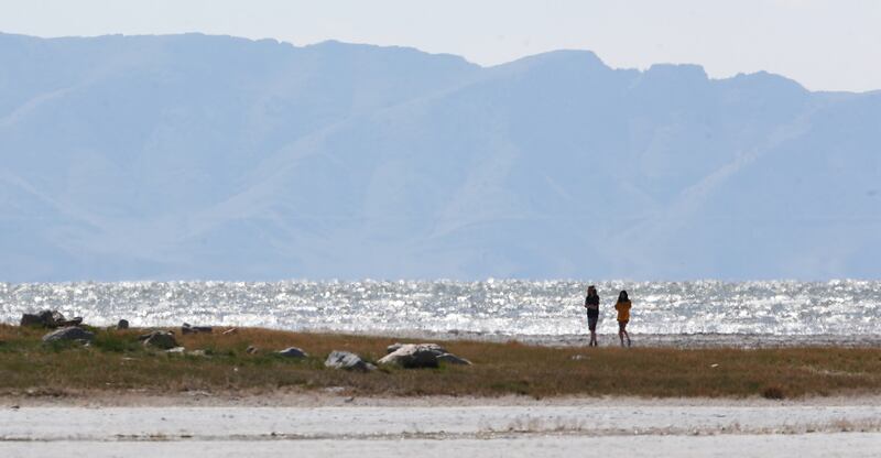 Two women walk on the beach near Saltair on the Great Salt Lake on Sunday, April 12, 2020.