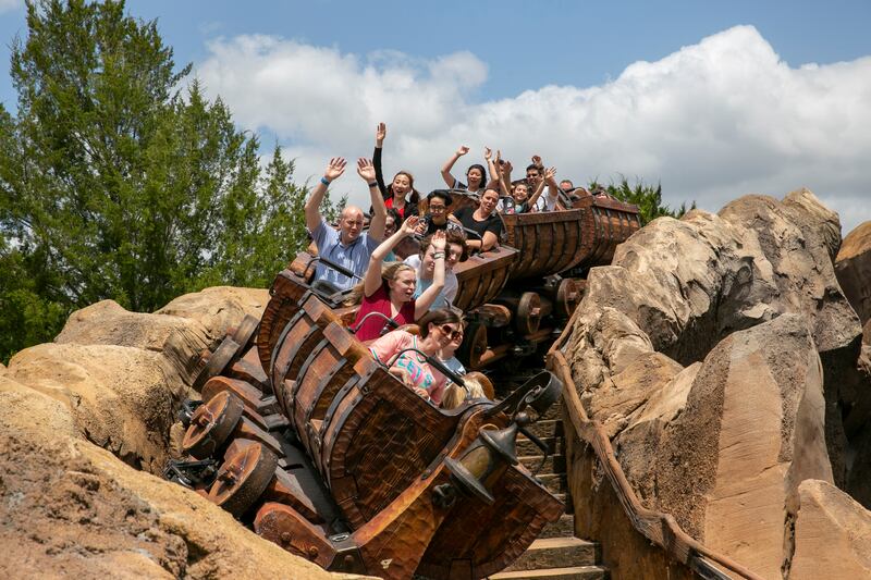 People ride the Seven Dwarfs Mine Train roller coaster at Magic Kingdom Park at Walt Disney World Resort in Lake Buena Vista, Florida.