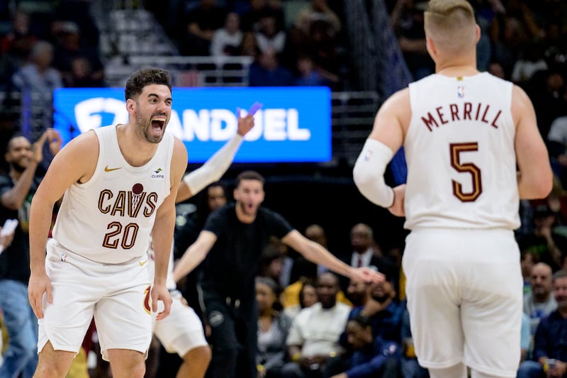 Cleveland Cavaliers forward Georges Niang (20) cheers for guard Sam Merrill (5) during the second half of the team's NBA basketball game against the New Orleans Pelicans in New Orleans, Wednesday, March 13, 2024. (AP Photo/Matthew Hinton)