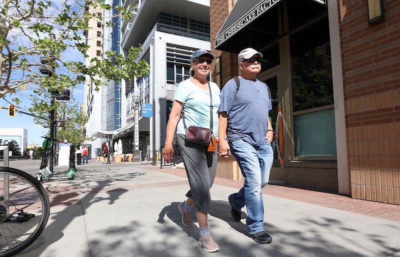 Sharee and Andrew Birrell smile as the walk in downtown Salt Lake City Friday morning without masks.