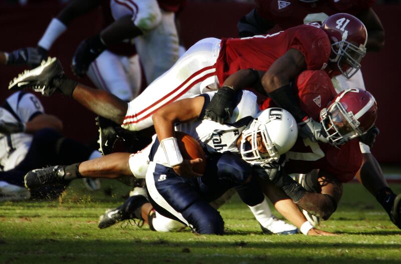 Alabama defenders Roman Harper, top, and Mark Anderson sack Utah State quarterback Leon Jackson III, bottom, during the second half of their game Saturday Oct. 29, 2005, at Bryant-Denny Stadium in Tuscaloosa, Ala. (AP Photo/Rob Carr)