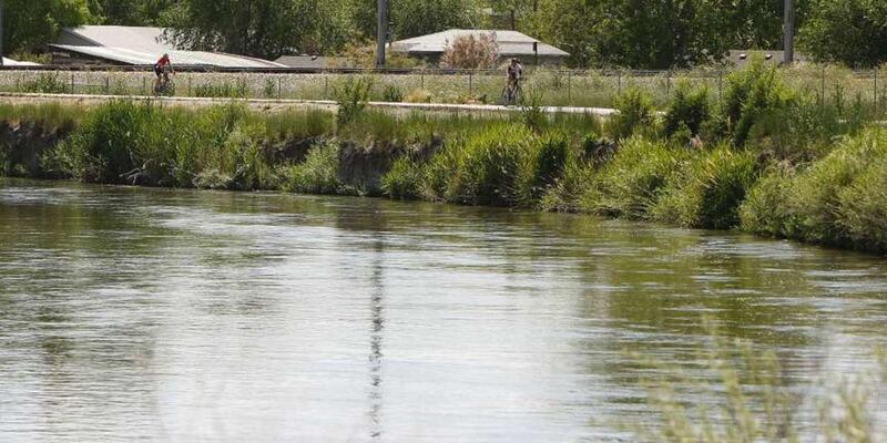 Cyclists ride along the Jordan River Parkway Trail at the Redwood Trailhead Park in West Valley City, Tuesday, June 2, 2015. Felony charges were filed Thursday against two businesses and their owners accused of dumping concrete mix and other materials alo