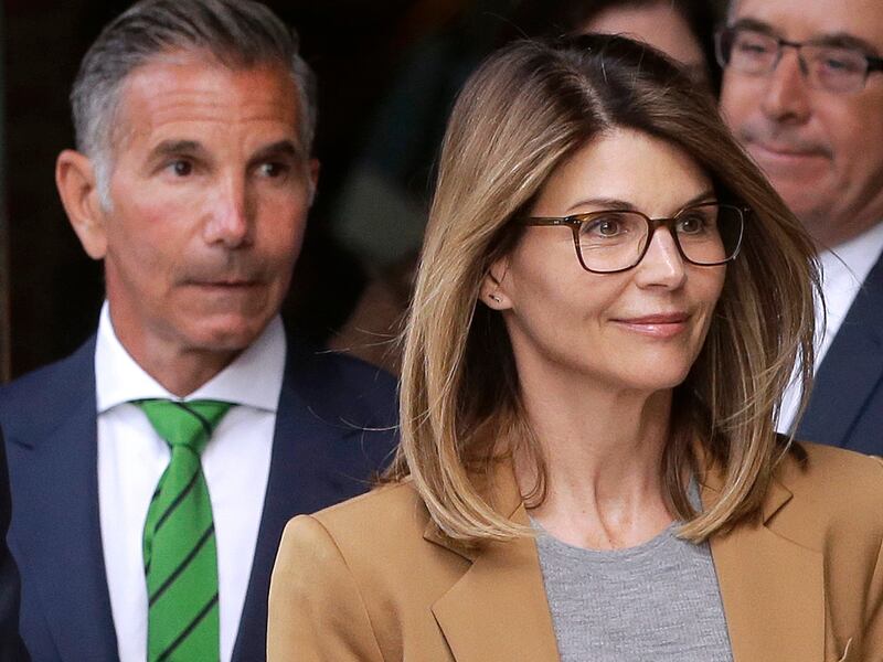 FILE - In this April 3, 2019 file photo, actress Lori Loughlin, front, and husband, clothing designer Mossimo Giannulli, left, depart federal court in Boston after facing charges in a nationwide college admissions bribery scandal. On Tuesday, April 9, Lou