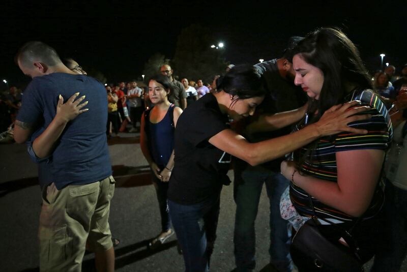 Members of Iglesia Cristiana Manatial en el Desierto pray with El Pasoans who came to hold vigil Monday, Aug. 5, 2019, outside the Walmart in El Paso, Texas, where a mass shooting took place on Saturday.