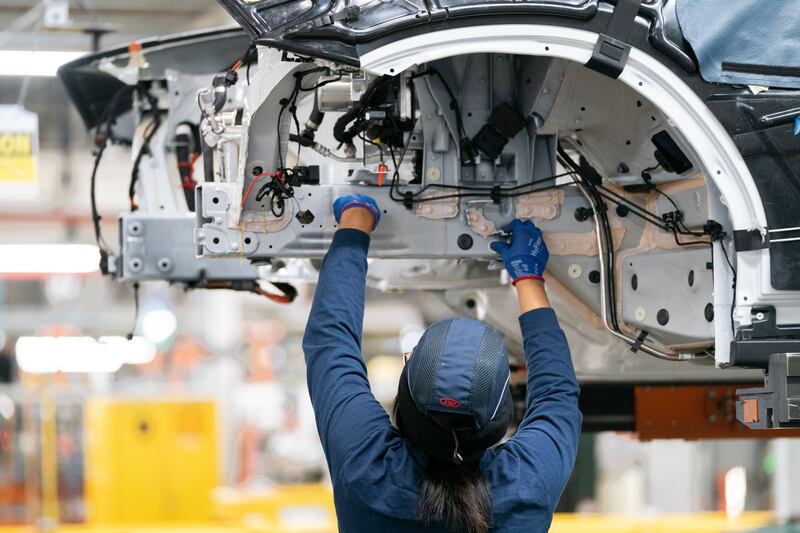 An employee works on a car on the assembly line at the BMW Spartanburg plant in Greer, S.C.