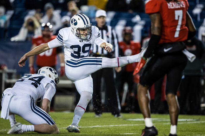 BYU kicker Jake Oldroyd follows through on a kick attempt against Western Kentucky. BYU punter Ryan Rehkow holds for the kick.