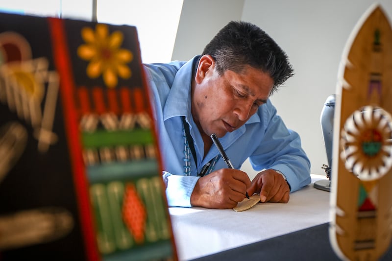 Randy Dukepoo, a Hopi, signs a finished piece during the Indian Art Market at the Natural History Museum of Utah in Salt Lake City on Sunday, Oct. 15, 2017.