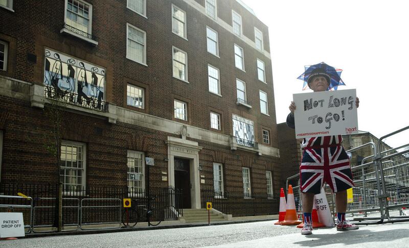 Terry Hutt poses for the media with a sign that reads 'Not Long to Go' as he waits with other royal fans for Kate, the Duchess of Cambridge to go into the Lindo wing at St Mary's Hospital to give birth to her second child in London, Friday, April 24, 2015