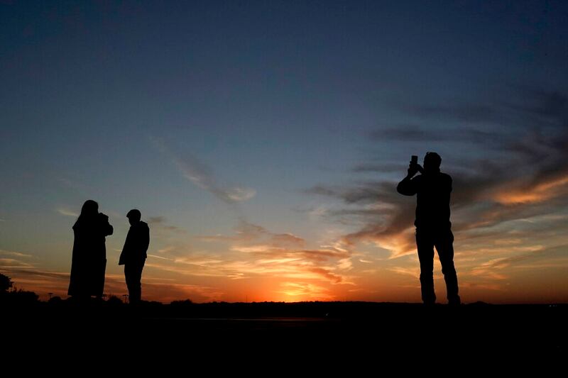 People watch the last sunset of daylight saving time.