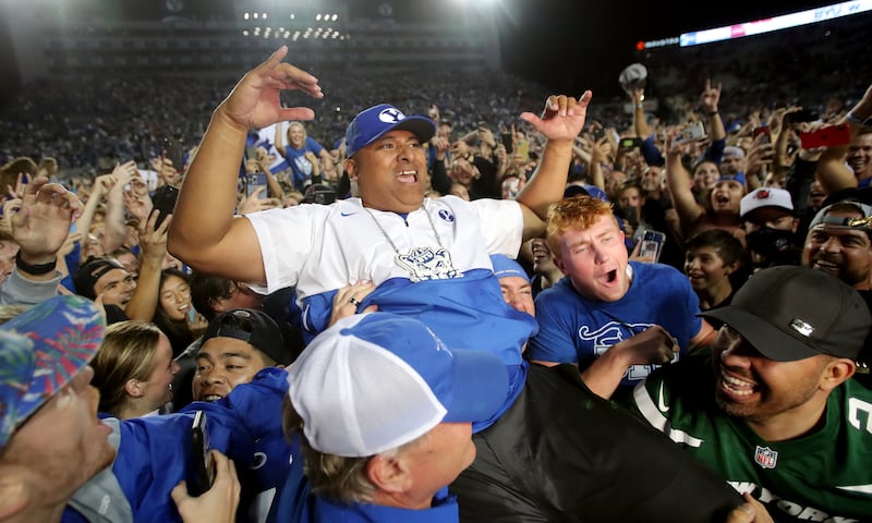 BYU football coach Kalani Sitake celebrates the Cougars’ win over Utah with fans at LaVell Edwards Stadium in Provo.