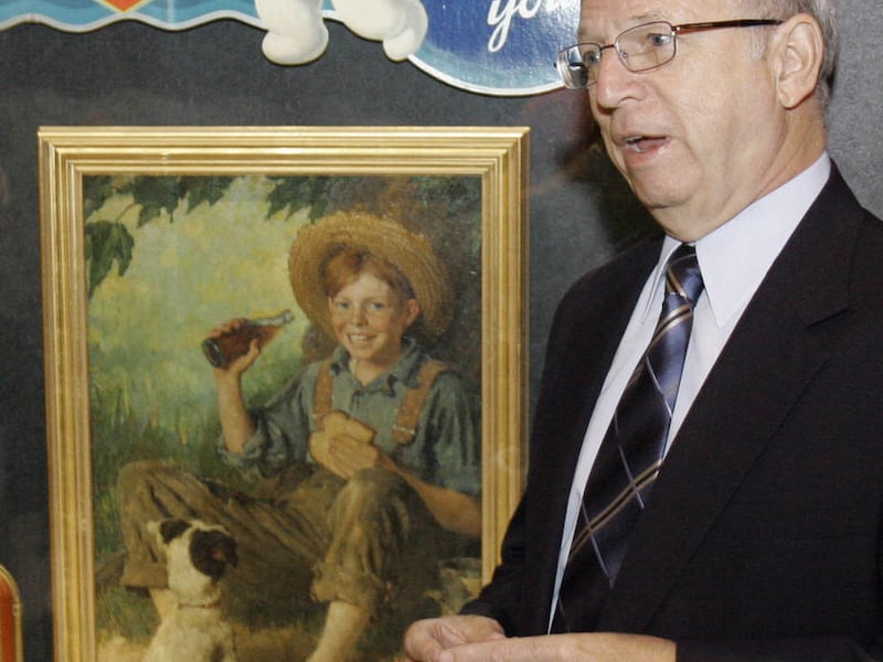 Coca-Cola\'s archivist Phil Mooney poses by one of the Norman Rockwell Coke paintings \"Barefoot Boy\" displayed in the lobby of the Coke museum in Atlanta, Ga. Friday, May 25, 2007.