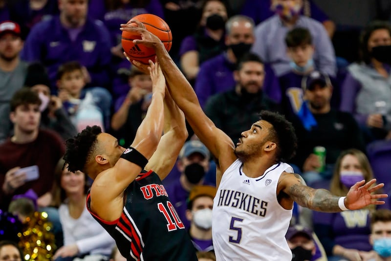 Washington guard Jamal Bey, right, blocks a shot by Utah guard Marco Anthony during game, Saturday, Jan. 29, 2022, in Seattle.