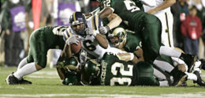 Curtis Brown (6) is brought down by a group of Colorado State defenders on Saturday night in Fort Collins, Colo.