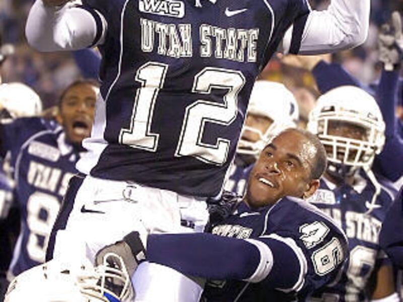 Former USU quarterback Riley Nelson, shown after the Aggies upset Fresno State in 2006, is transferring to BYU.