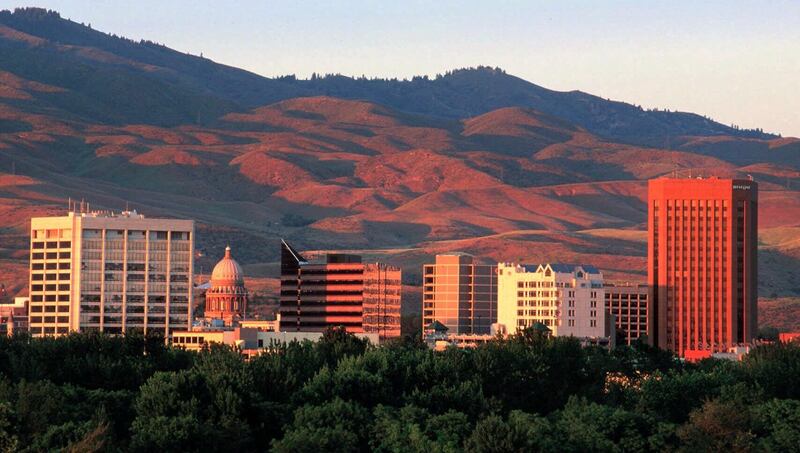 Boise rises in front of the foothills as the late afternoon sun gives the skyline a golden hue.