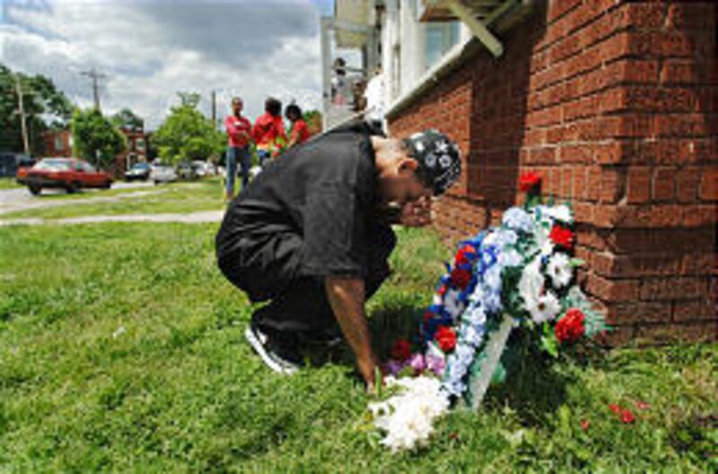 Friends and family gather to place flowers at the site where four teenagers were killed Sunday in Huntington, W.Va.