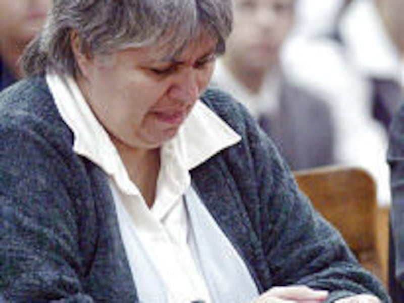 Diane Odell clutches a rosary while listening to her defense lawyer during his closing statement.