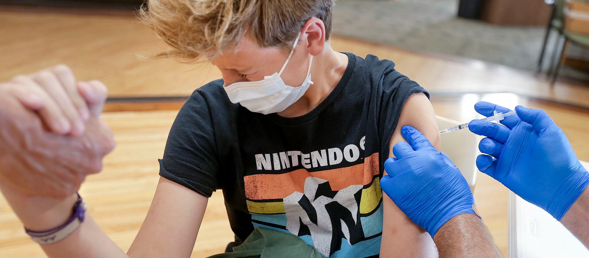 Dean Liljenquist, 13, of Bountiful, gets a COVID-19 vaccination at the South Davis Senior Activity Center in Bountiful.