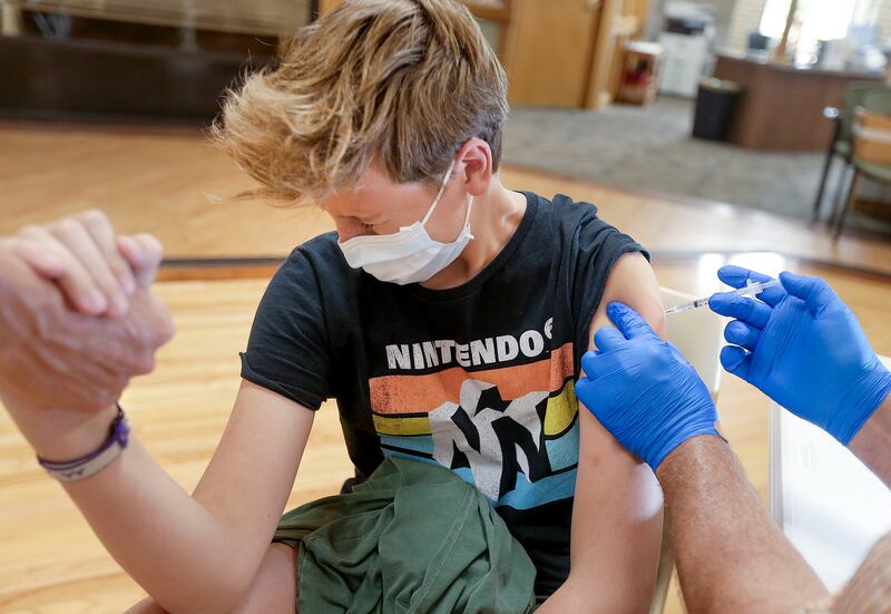 Dean Liljenquist, 13, of Bountiful, gets a COVID-19 vaccination at the South Davis Senior Activity Center in Bountiful.