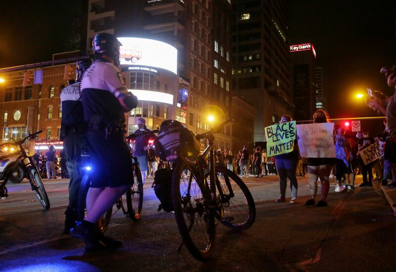 Police watch protesters in downtown Columbus, Ohio, Thursday, May 28, 2020, during a demonstration over the death of George Floyd in police custody Monday in Minneapolis.
