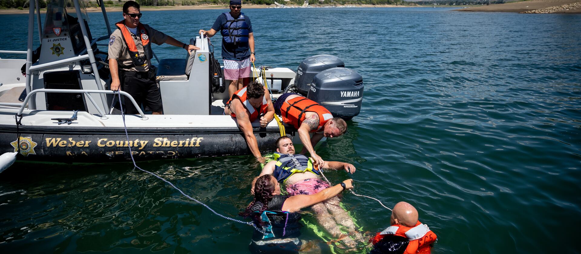 During a mock boating accident, a firefighter is pilled from the water for rescue training.