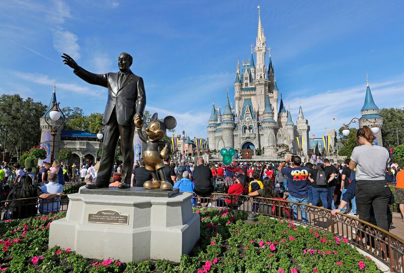 In this Jan. 9, 2019 photo, a statue of Walt Disney and Micky Mouse stands in front of the Cinderella Castle at the Magic Kingdom at Walt Disney World in Lake Buena Vista, Fla.