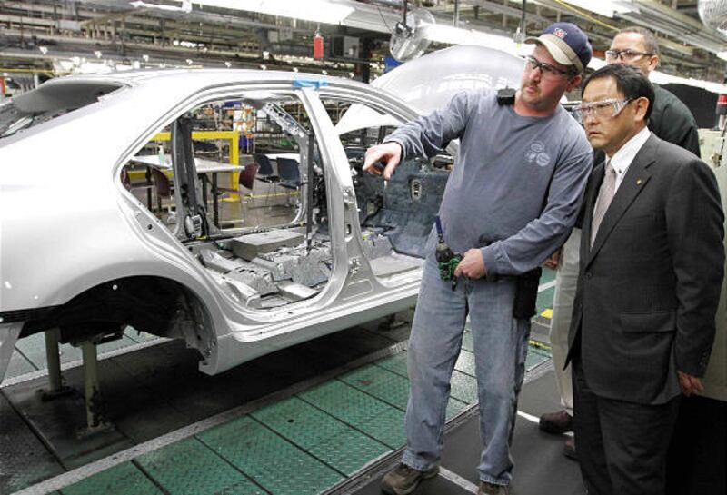 Toyota President Akio Toyoda, right, and production team member Bobby Parks look over the assembly line at the Toyota Motor Manufacturing plant in Georgetown, Ky., on Thursday.