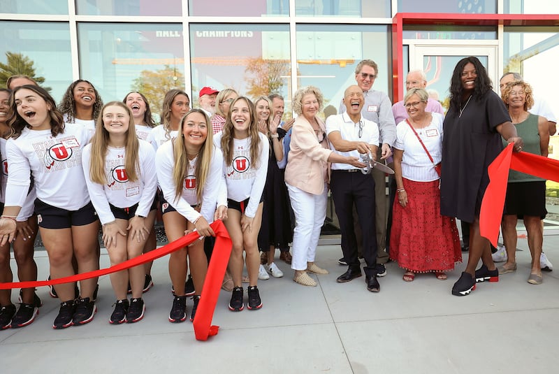 Utah gymnastics head coach Tom Farden holds the scissors during a ribbon-cutting event for the Dumke Gymnastics Center’s expansion.