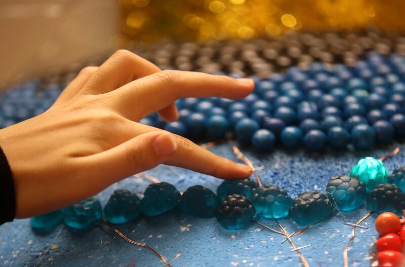 Yukako Ogura glues candy on "One Sky" for Macy's Candy Windows at Salt Lake Community College in Salt Lake City on Monday, Oct. 22, 2018.