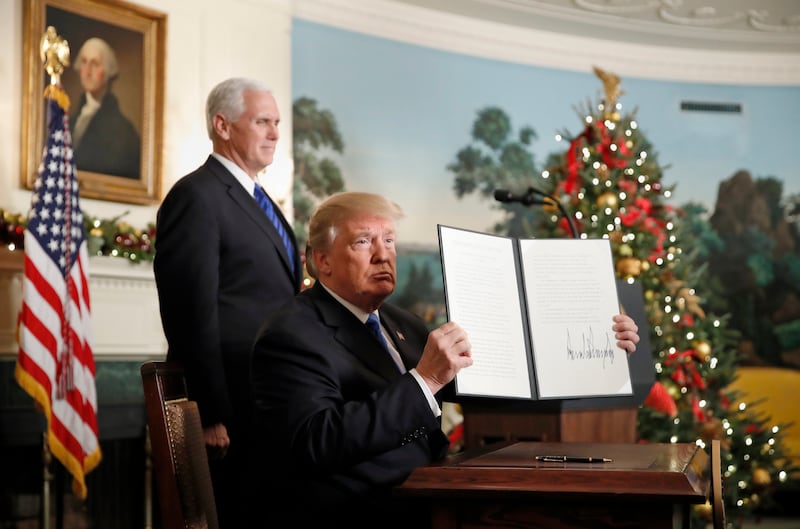 President Donald Trump, accompanied by Vice President Mike Pence, holds up a signed proclamation recognizing Jerusalem as the capital of Israel in the Diplomatic Reception Room of the White House, Wednesday, Dec. 6, 2017, in Washington. (AP Photo/Alex Bra