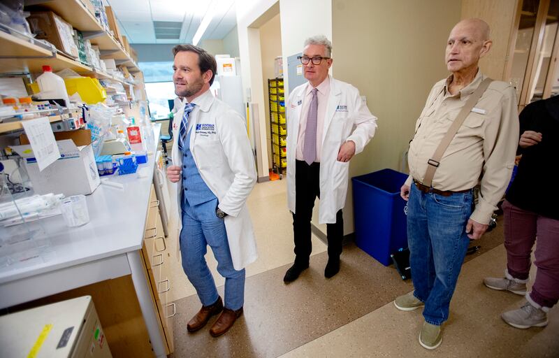 Dr. Conan Kinsey, a physician-scientist at the Huntsman Cancer Institute, left, and Martin McMahon, a cancer researcher at the institute and professor of dermatology at the University of Utah, talk with Gordon Chamberlain, Kinsey's patient, about about a