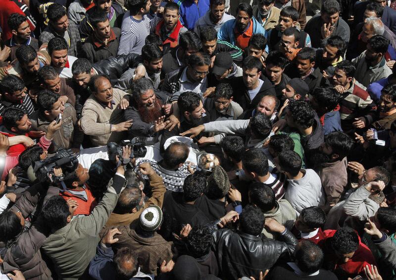 Kashmiri Muslims crowd around the body of Moulvi Showkat Ahmed Shah, the president of the religious group Jamiat-e-ahle Hadith, who was killed in a blast as he was entering a mosque in Srinagar, India, Friday, April 8, 2011. A blast outside a mosque in th