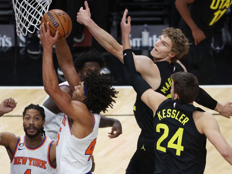 New York Knicks center Jericho Sims (45) grabs a rebound over Utah Jazz center Walker Kessler (24) in Salt Lake City on Tuesday, Nov. 15, 2022. The Knicks won 113-104.