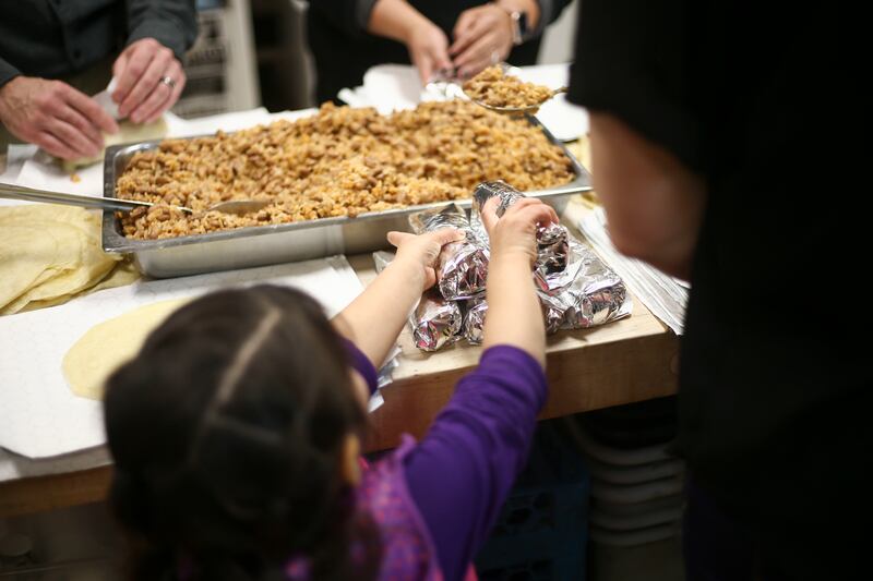 Mare Sandoval, 5, gathers burritos made by volunteers at Rico Brand headquarters in Salt Lake City on Thursday, March 7, 2019. After making the burritos the volunteers handed them out to homeless individuals.