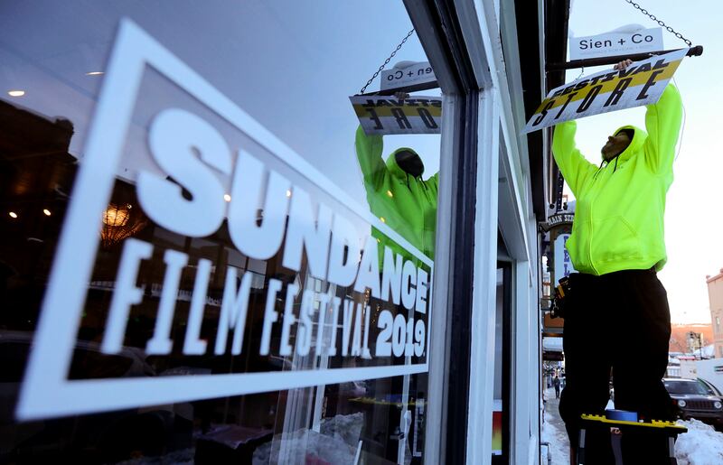Marc Lee hangs a Festival Store sign before the start of the 2019 Sundance Film Festival in Park City on Tuesday, Jan. 22, 2019.